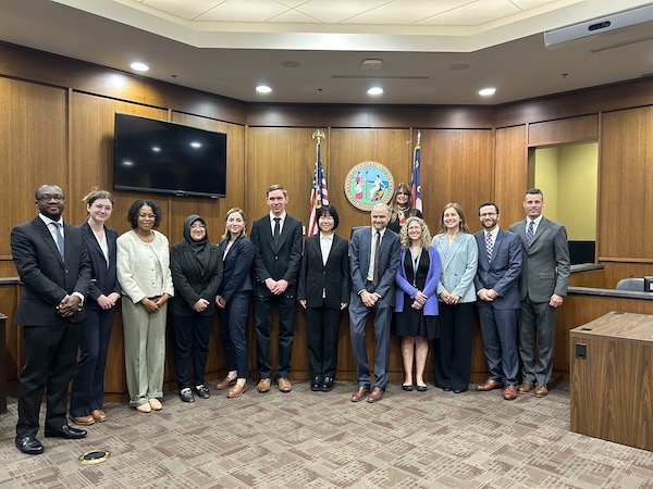 students and attorneys stand in court for a photo