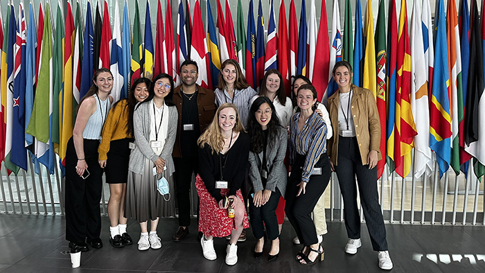 students standing in front of a row of flags