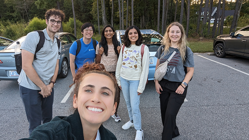 Students posing in parking lot outside clinic