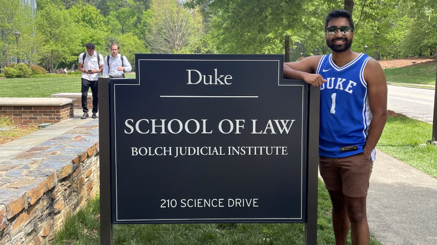 Moksh Gudala standing at Duke Law sign