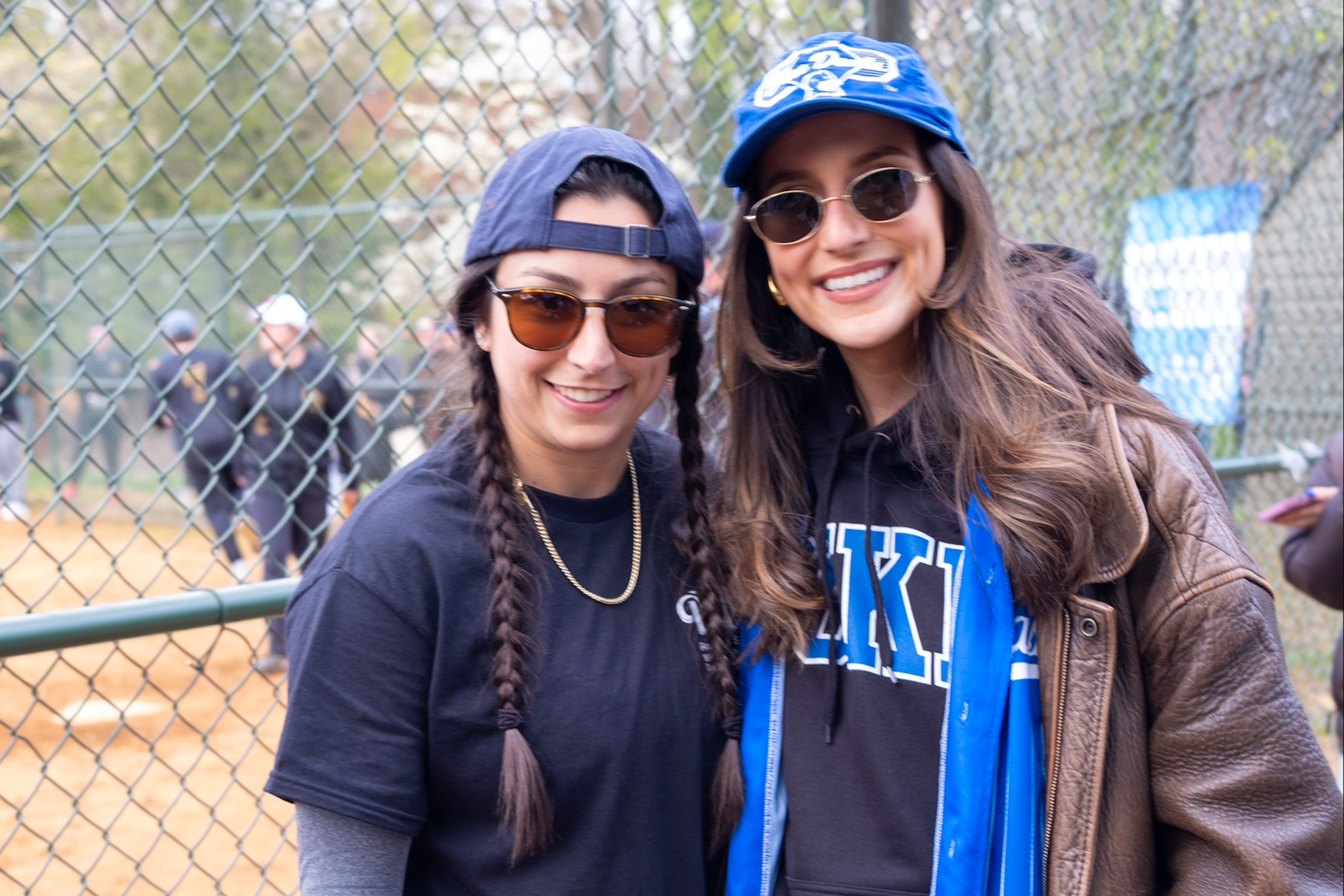 Herfi standing with fellow student at softball game