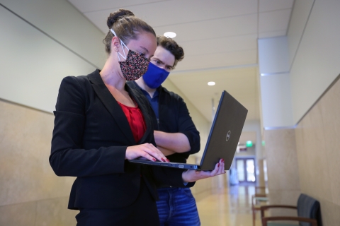 Student-attorneys looking at a laptop